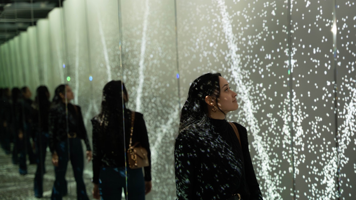 Guest exploring mirrored light display at World of Illusion, Dublin.