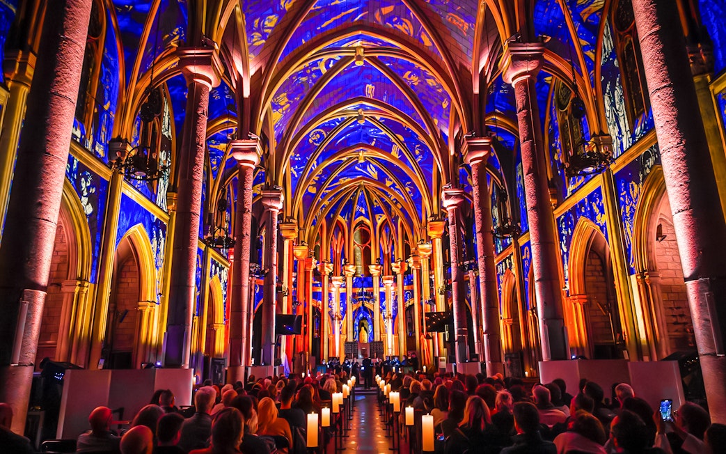 Interiors of Manchester Cathedral during LUMINISCENCE 360° Immersive Show with vibrant lighting.