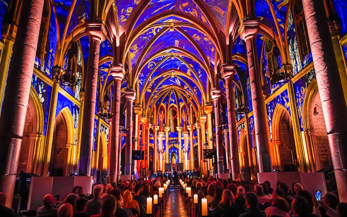 Interiors of Manchester Cathedral during LUMINISCENCE 360° Immersive Show with vibrant lighting.