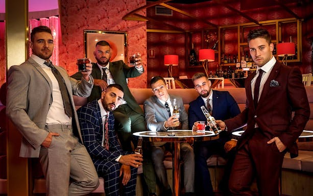 Men in suits enjoying drinks at The Pink Flamingo Ripped Show lounge.