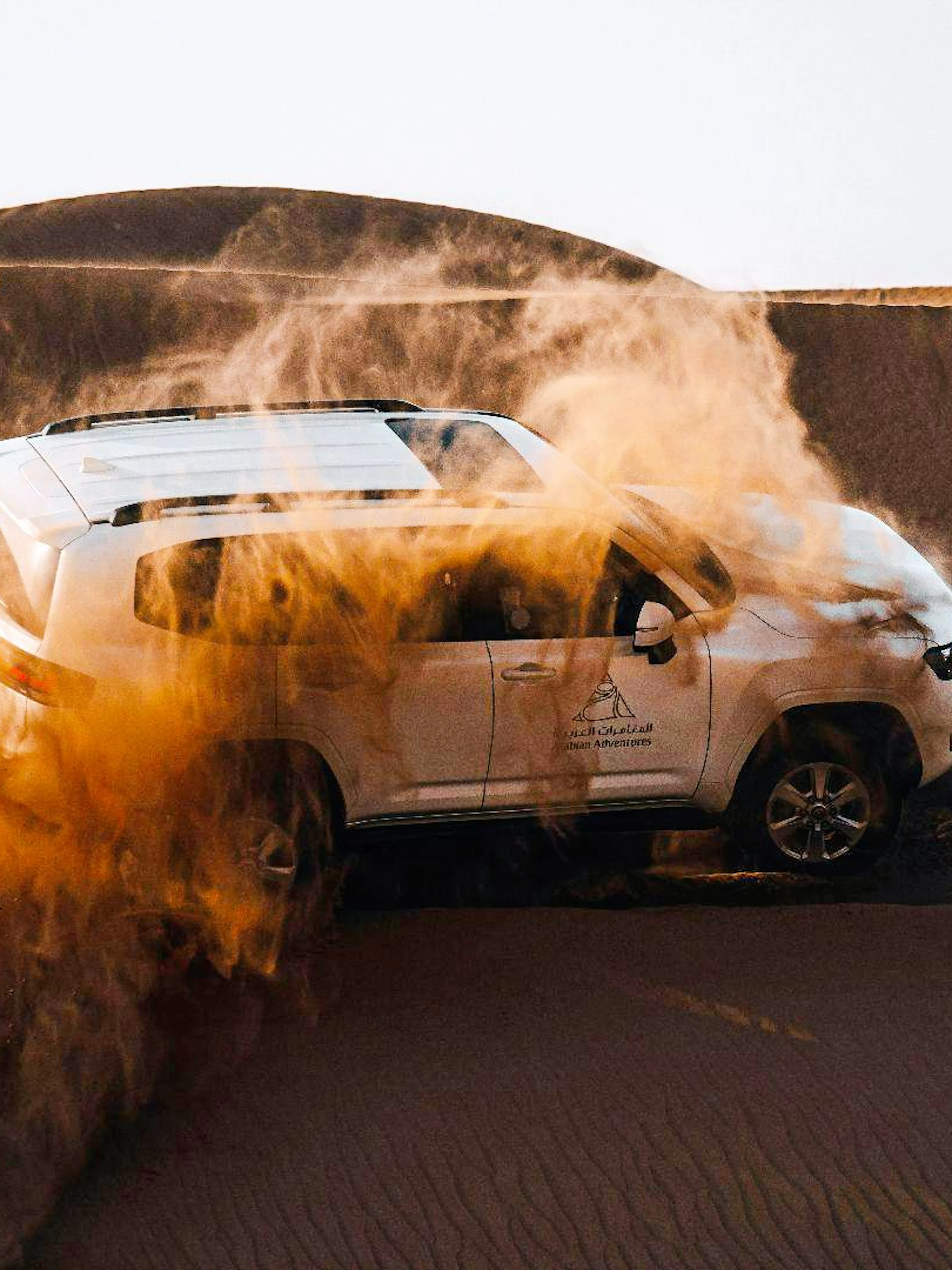 SUV driving through sand dunes during Dubai desert safari.
