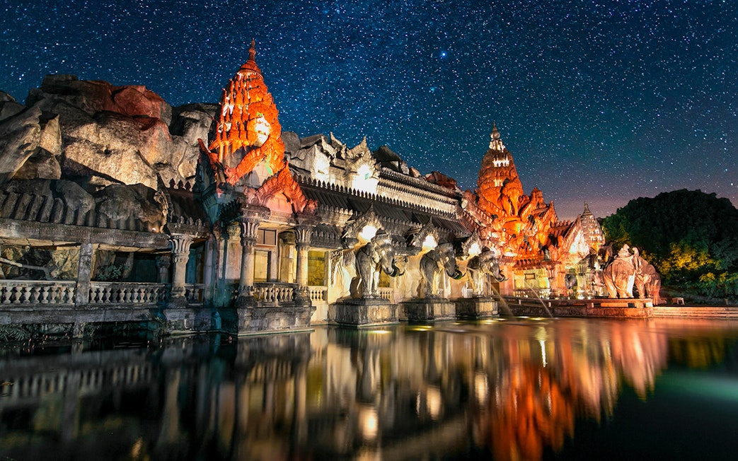 Palace Court at Phuket Fantasea illuminated at night with elephant statues and starry sky.