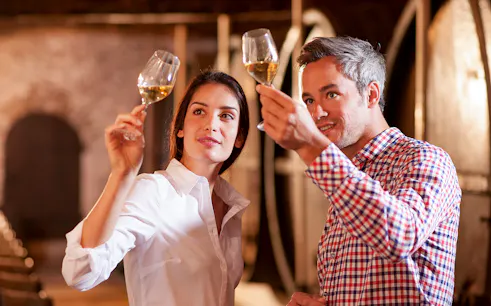 Tourists tasting wine at Château de Crémat cellar.
