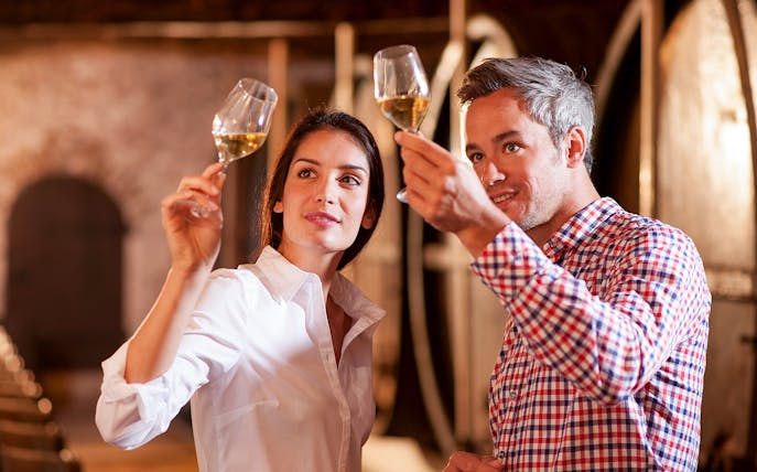 Tourists tasting wine at Château de Crémat cellar.