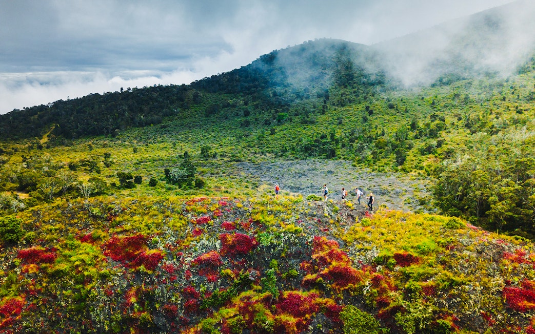 Guests hiking on vibrant volcanic terrain during the Hidden Craters Hike.