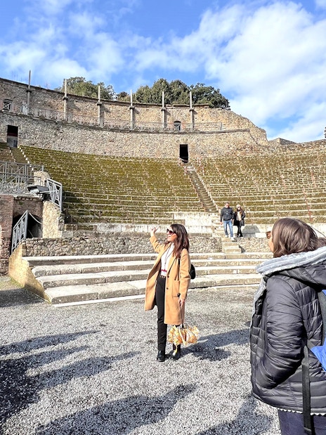 Tourists exploring the ancient amphitheater in Herculaneum, Pompeii.