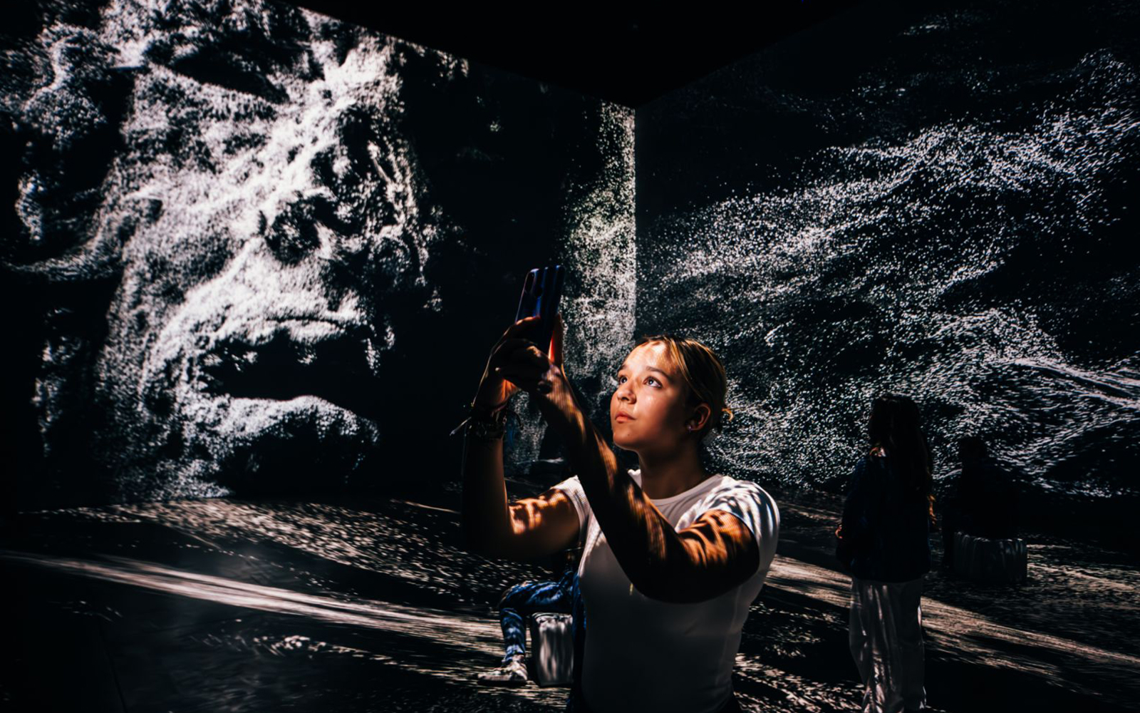 Person exploring immersive Pompeii exhibit with digital projections.
