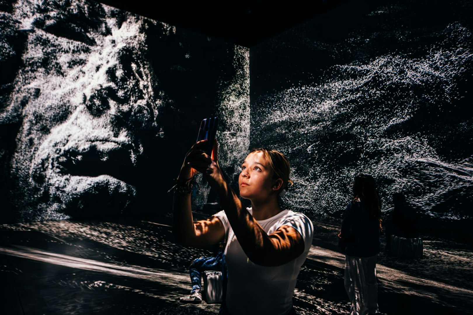 Person exploring immersive Pompeii exhibit with digital projections.