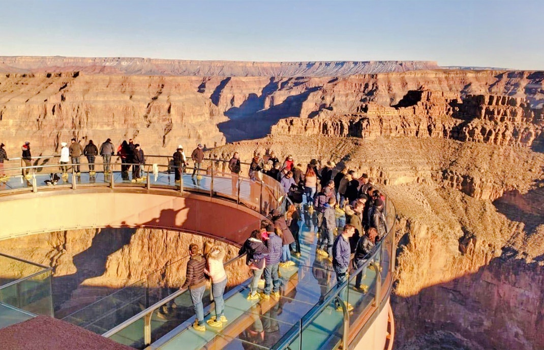 Visitors on the Skywalk bridge overlooking the Grand Canyon during a West Airplane Tour.