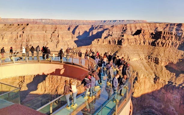 Visitors on the Skywalk bridge overlooking the Grand Canyon during a West Airplane Tour.