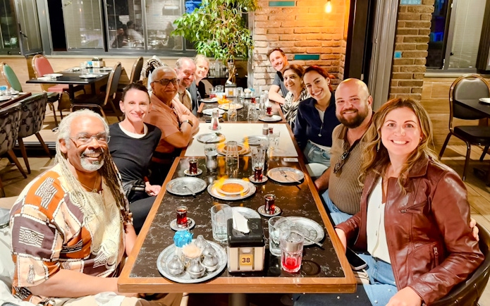 Group enjoying a traditional Turkish dinner with tea at a restaurant.