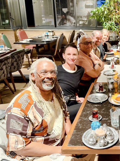 Group enjoying a traditional Turkish dinner with tea at a restaurant.