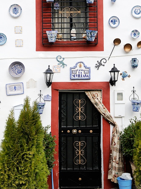Colorful ceramic plates and pots on a white wall in Albaicin, Granada.