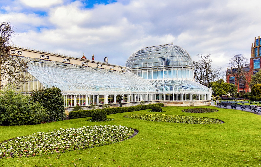 Belfast Botanic Garden glasshouse with lush greenery and vibrant flowers.