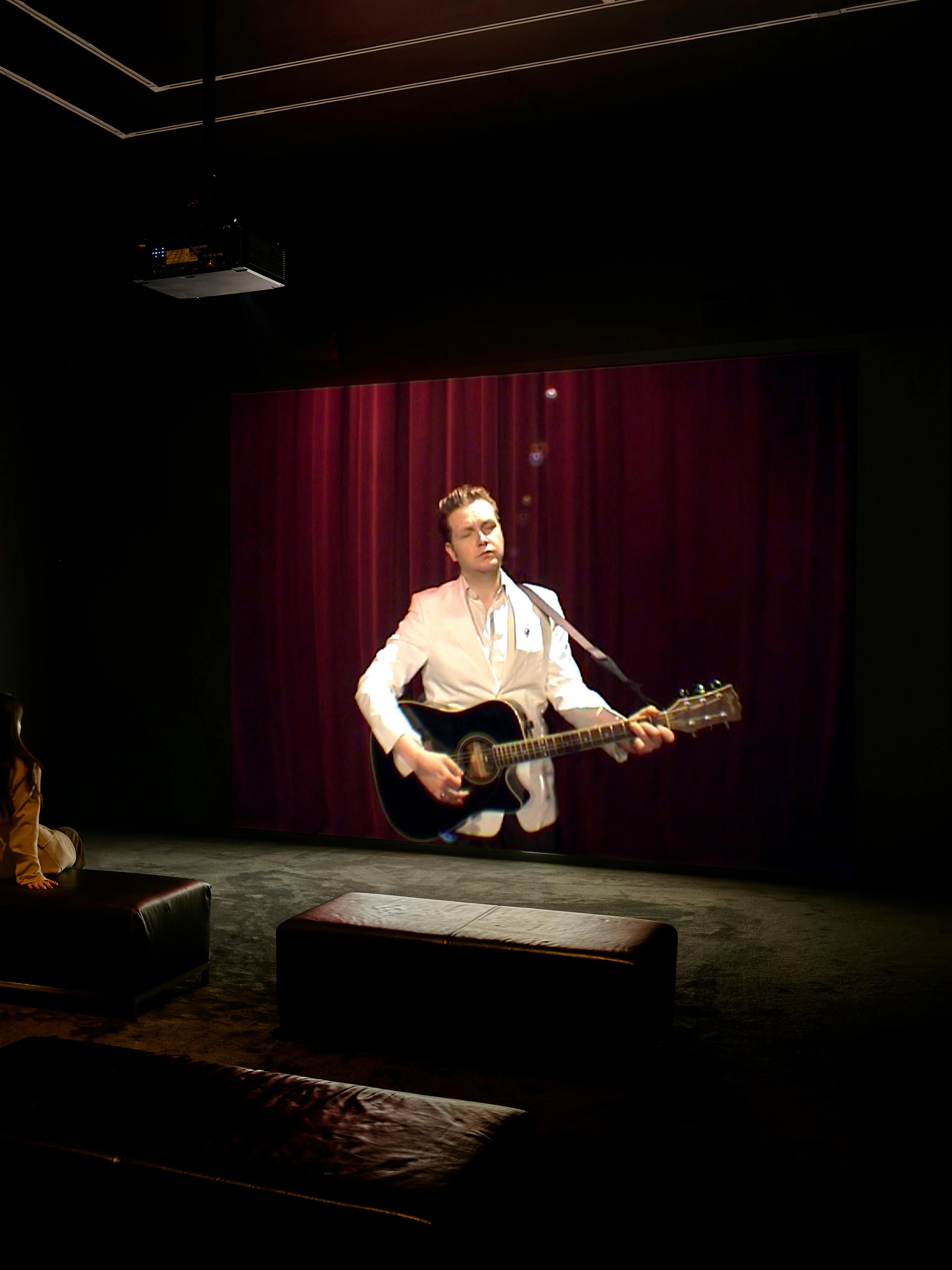 Visitor watching Ragnar Kjartansson's video performance at National Gallery of Victoria exhibition.