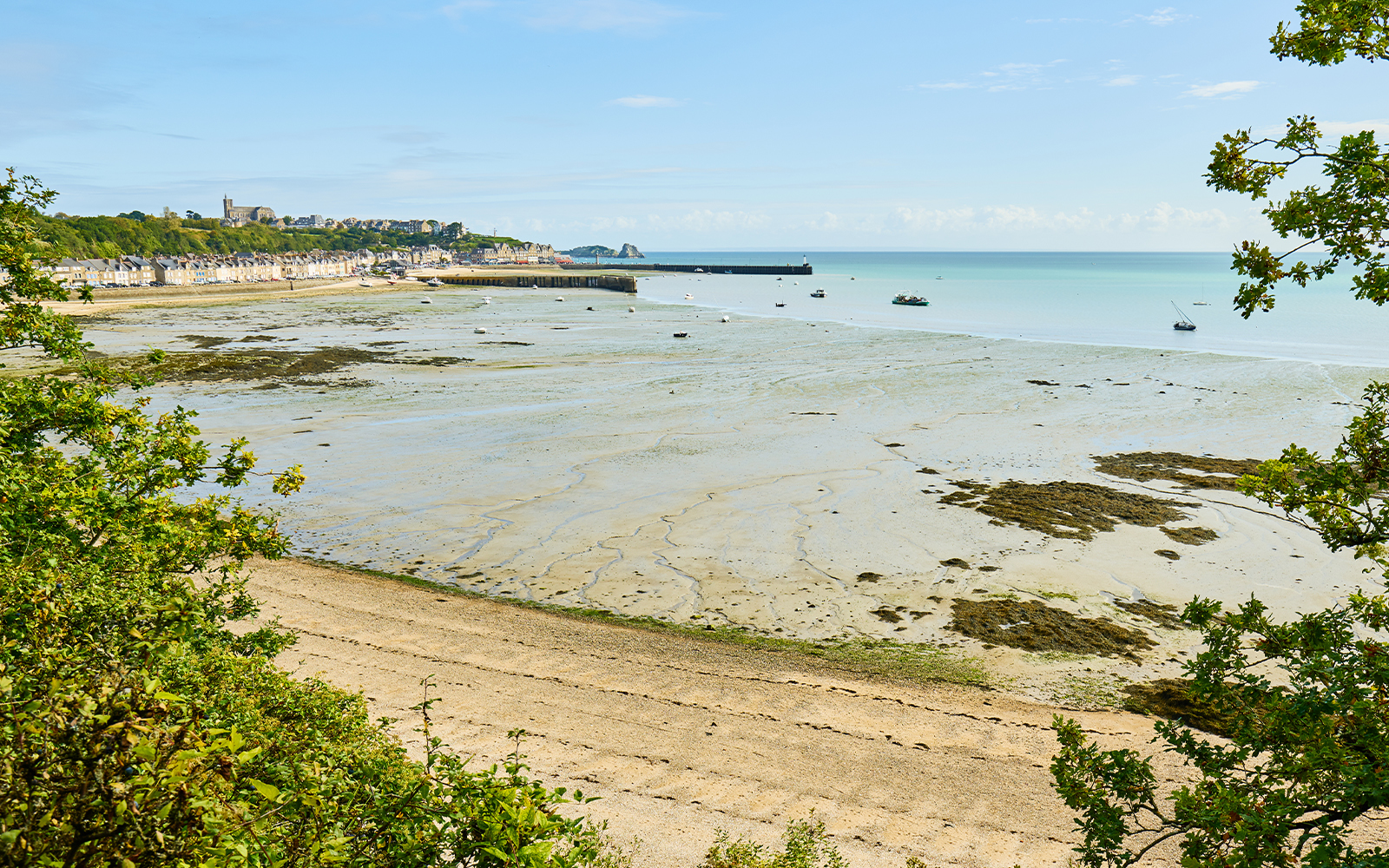 Mont Saint Michel bay with tidal flats and distant village in Normandy, France.