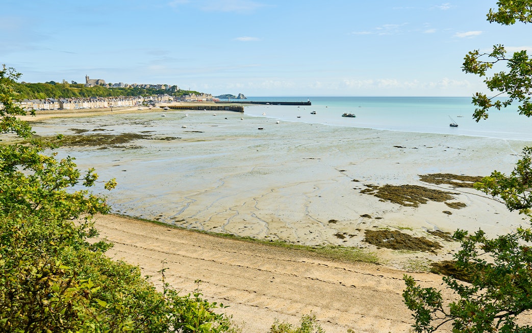 Mont Saint Michel bay with tidal flats and distant village in Normandy, France.