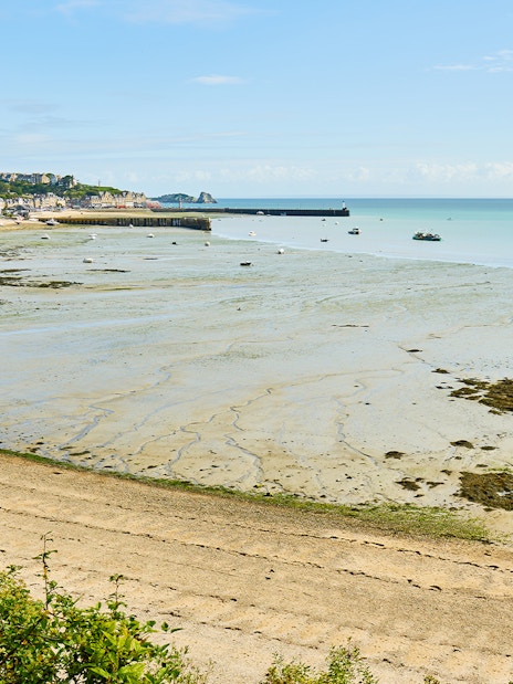 Mont Saint Michel bay with tidal flats and distant village in Normandy, France.