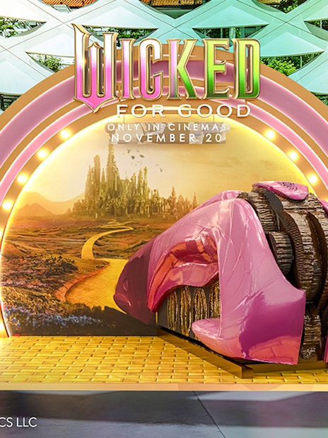 Wicked for Good display at Universal Studios Singapore featuring a pink shoe and Emerald City backdrop.