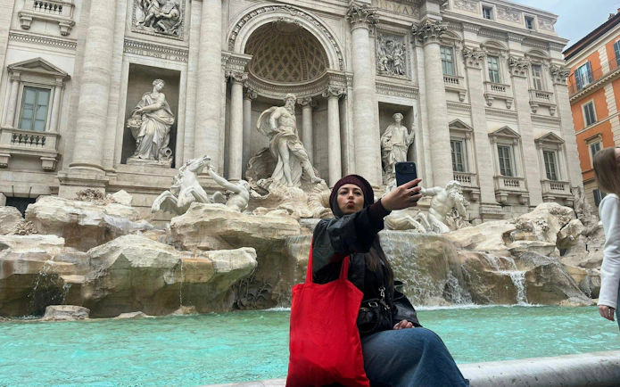 Trevi Fountain with visitor taking selfie, Rome, part of Trevi District Underground guided tour.