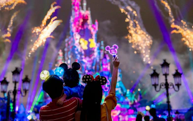 Family watching fireworks at Hong Kong Disneyland castle.