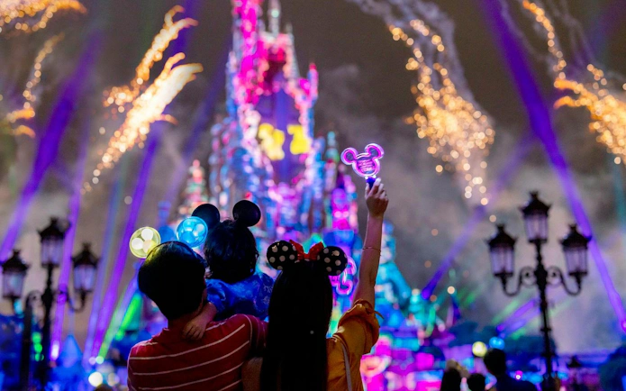 Family watching fireworks at Hong Kong Disneyland castle.