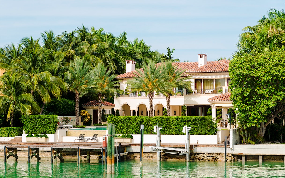 Luxurious mansion with palm trees on Star Island, Miami waterfront.