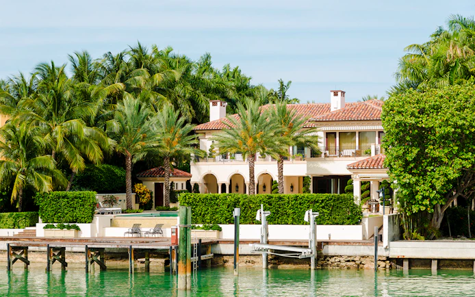 Luxurious mansion with palm trees on Star Island, Miami waterfront.