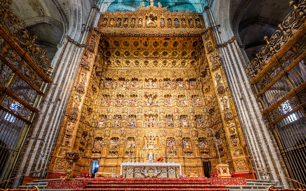 Altar of Seville Cathedral with intricate gold detailing on a guided tour.