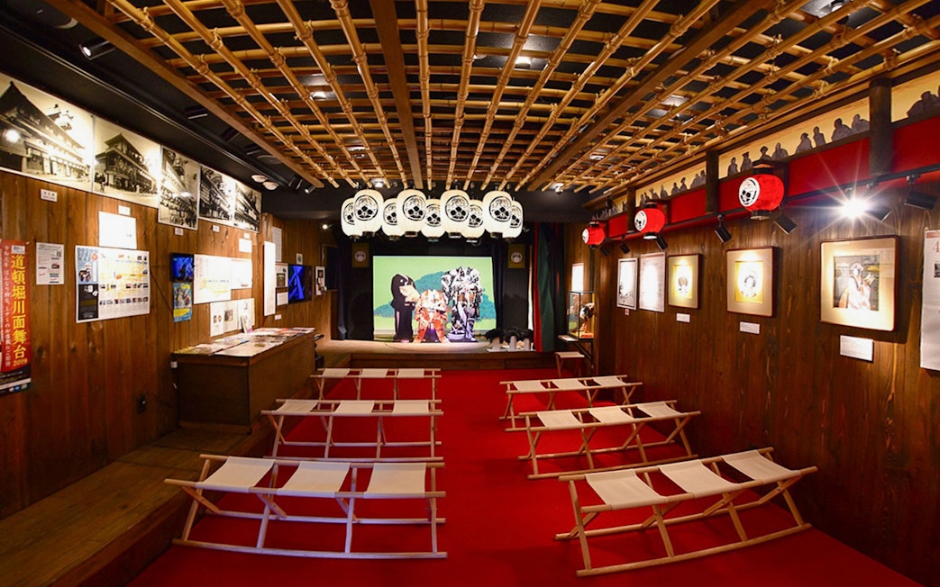 Interior of Osaka Dotonbori Museum Namikiza with traditional seating and stage display.