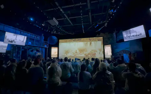 Visitors watching Niagara Falls film in theater during winter tour, Niagara Falls, USA.