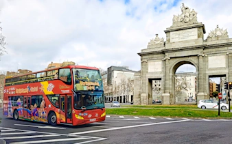 Madrid sightseeing bus passing Puerta de Alcalá.