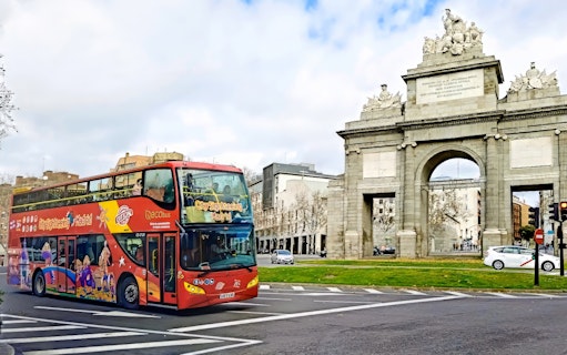 Madrid sightseeing bus passing Puerta de Alcalá.