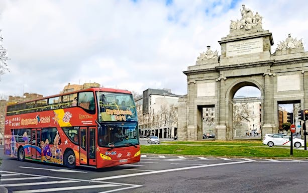 Madrid sightseeing bus passing Puerta de Alcalá.