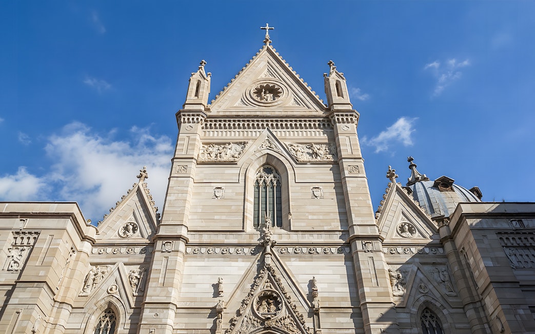 Sansevero Chapel facade with intricate sculptures and architectural details under a blue sky.