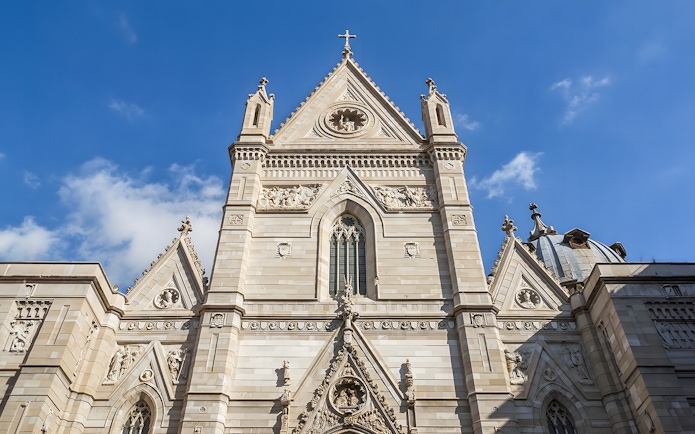 Sansevero Chapel facade with intricate sculptures and architectural details under a blue sky.