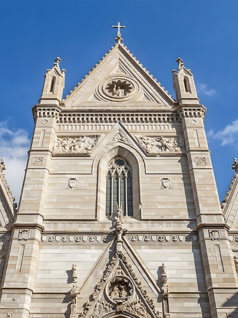 Sansevero Chapel facade with intricate sculptures and architectural details under a blue sky.