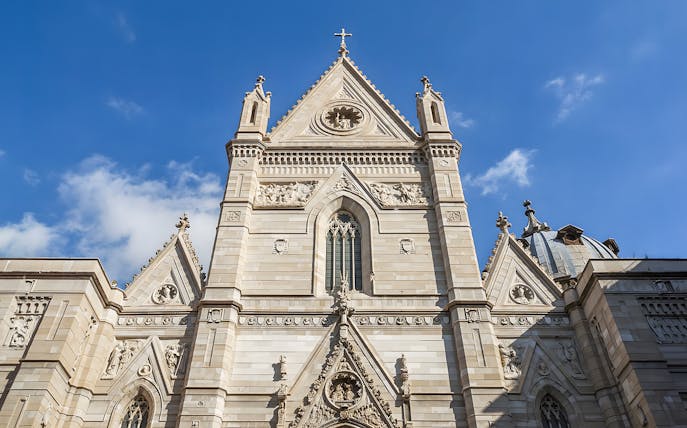 Sansevero Chapel facade with intricate sculptures and architectural details under a blue sky.
