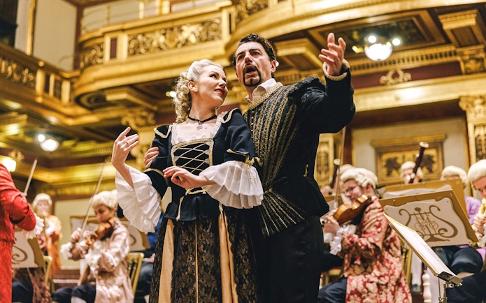 Mozart Orchestra performing in Vienna's Golden Hall, musicians in period costumes.