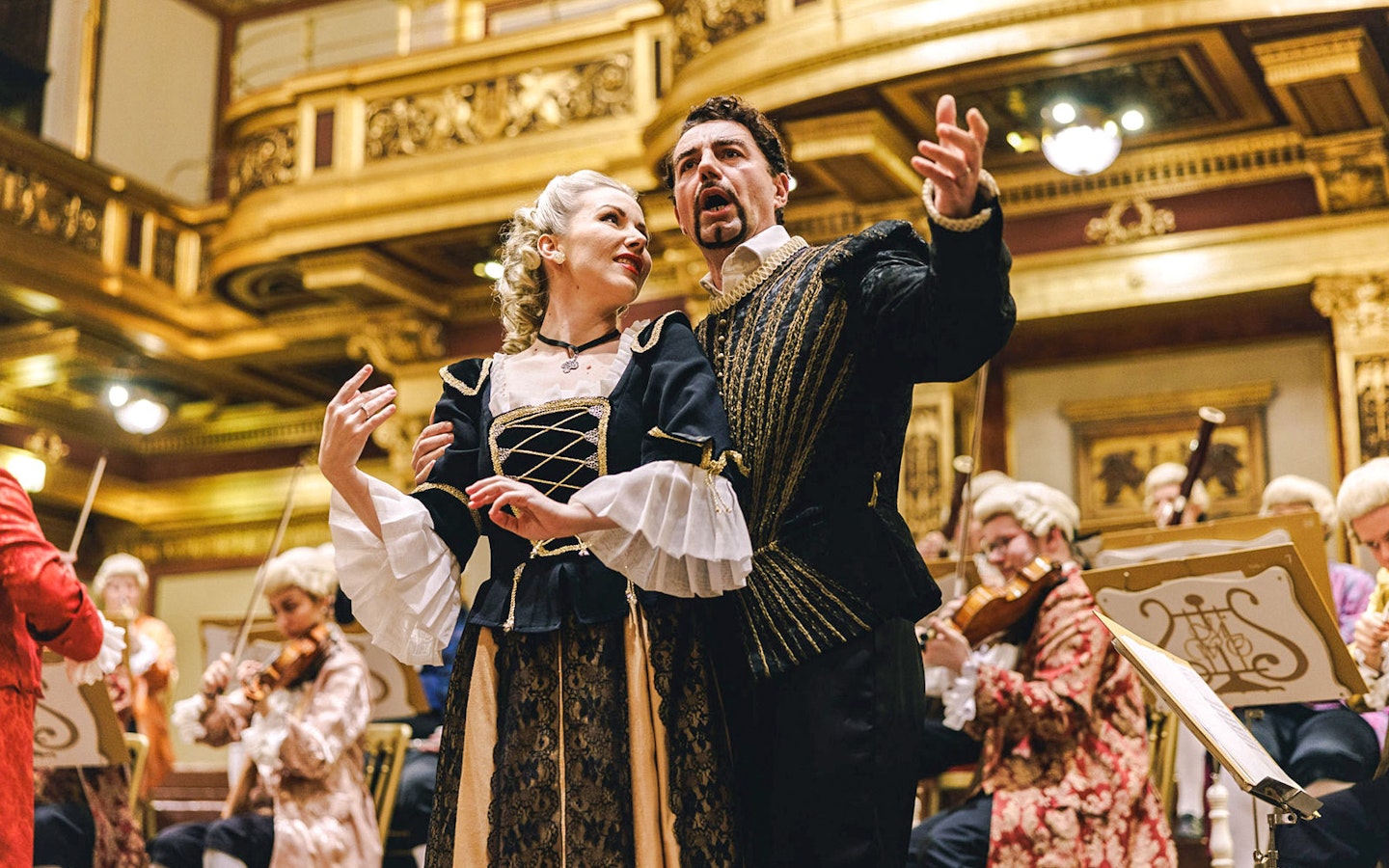 Mozart Orchestra performing in Vienna's Golden Hall, musicians in period costumes.