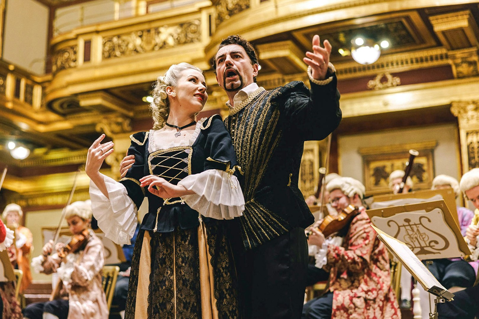 Mozart Orchestra performing in Vienna's Golden Hall, musicians in period costumes.
