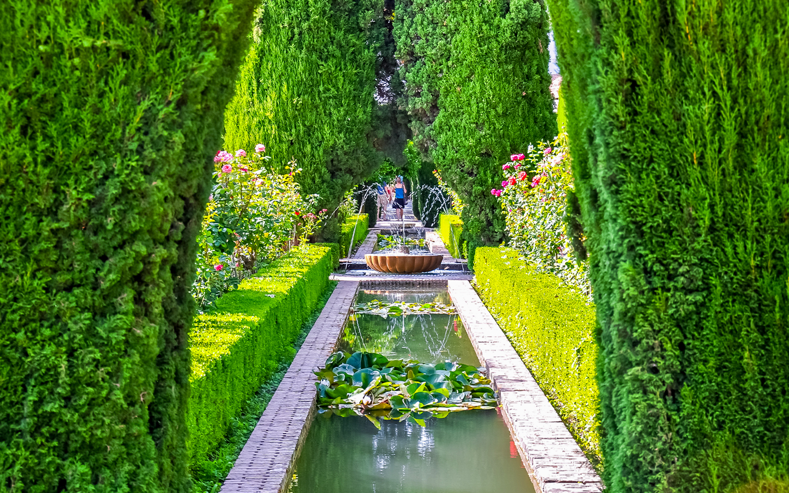 Alhambra garden path with fountain and hedges, Granada, Spain.
