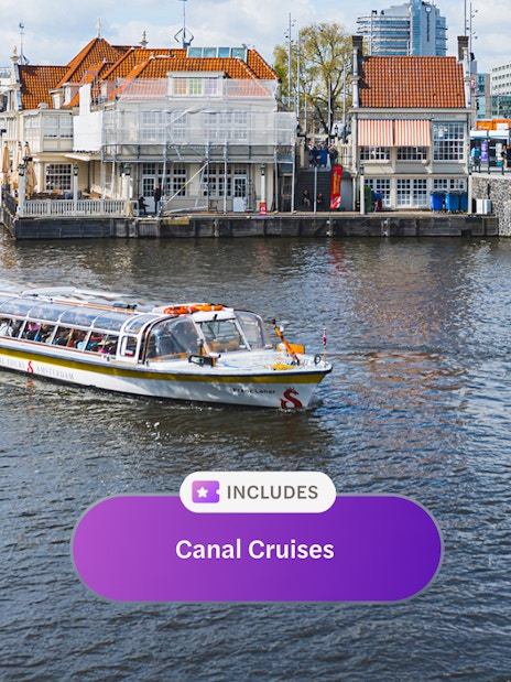 Canal cruise boat on Amsterdam canal with historic buildings in the background.