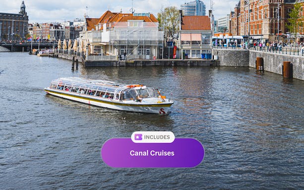 Canal cruise boat on Amsterdam canal with historic buildings in the background.