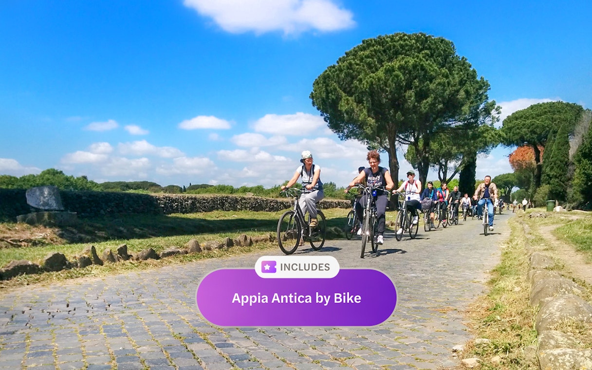 Cyclists riding along the ancient Appia Antica road in Rome, surrounded by greenery.