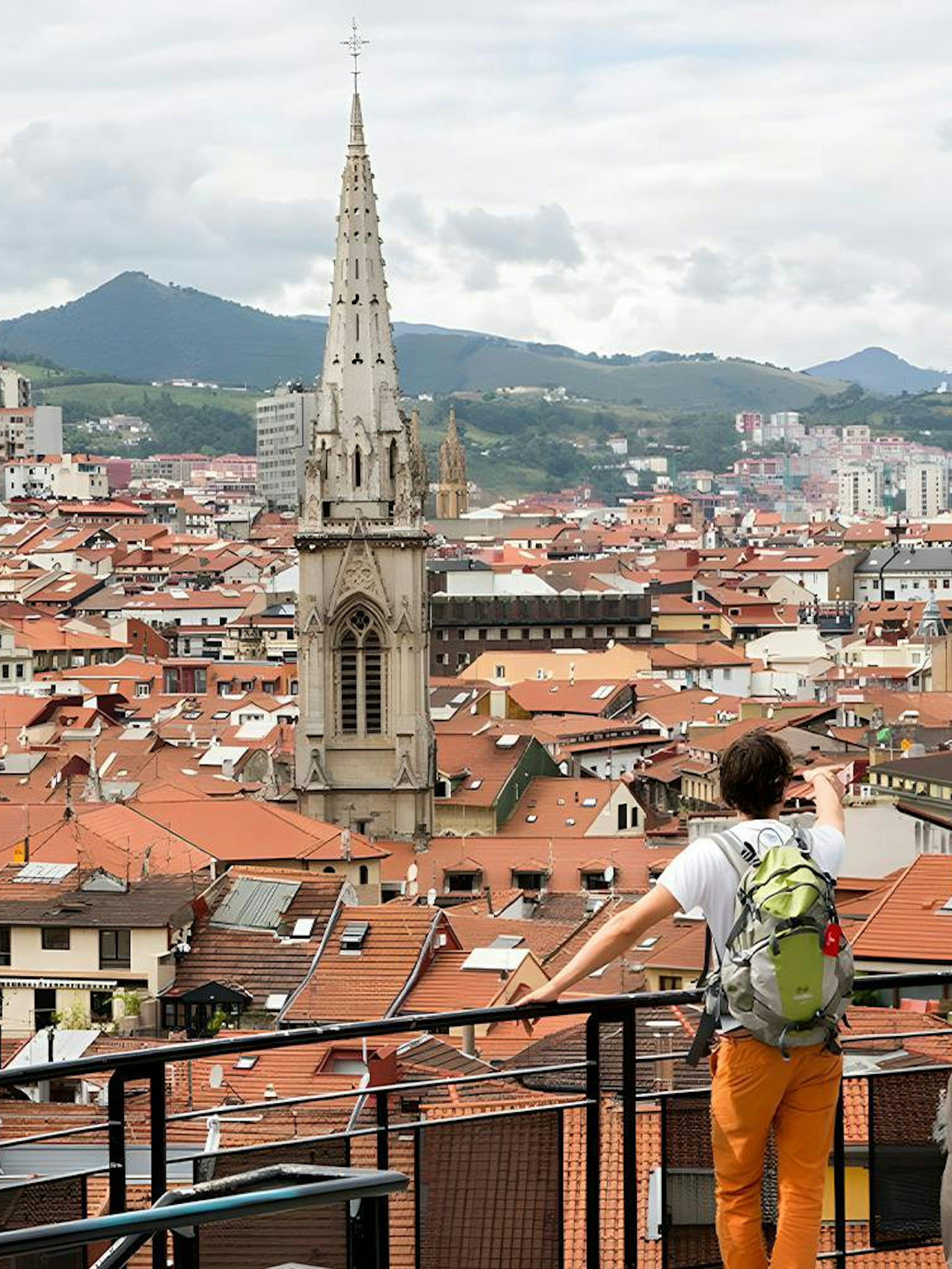 Panoramic view of Bilbao's Casco Viejo with Santiago Cathedral spire and terracotta rooftops.