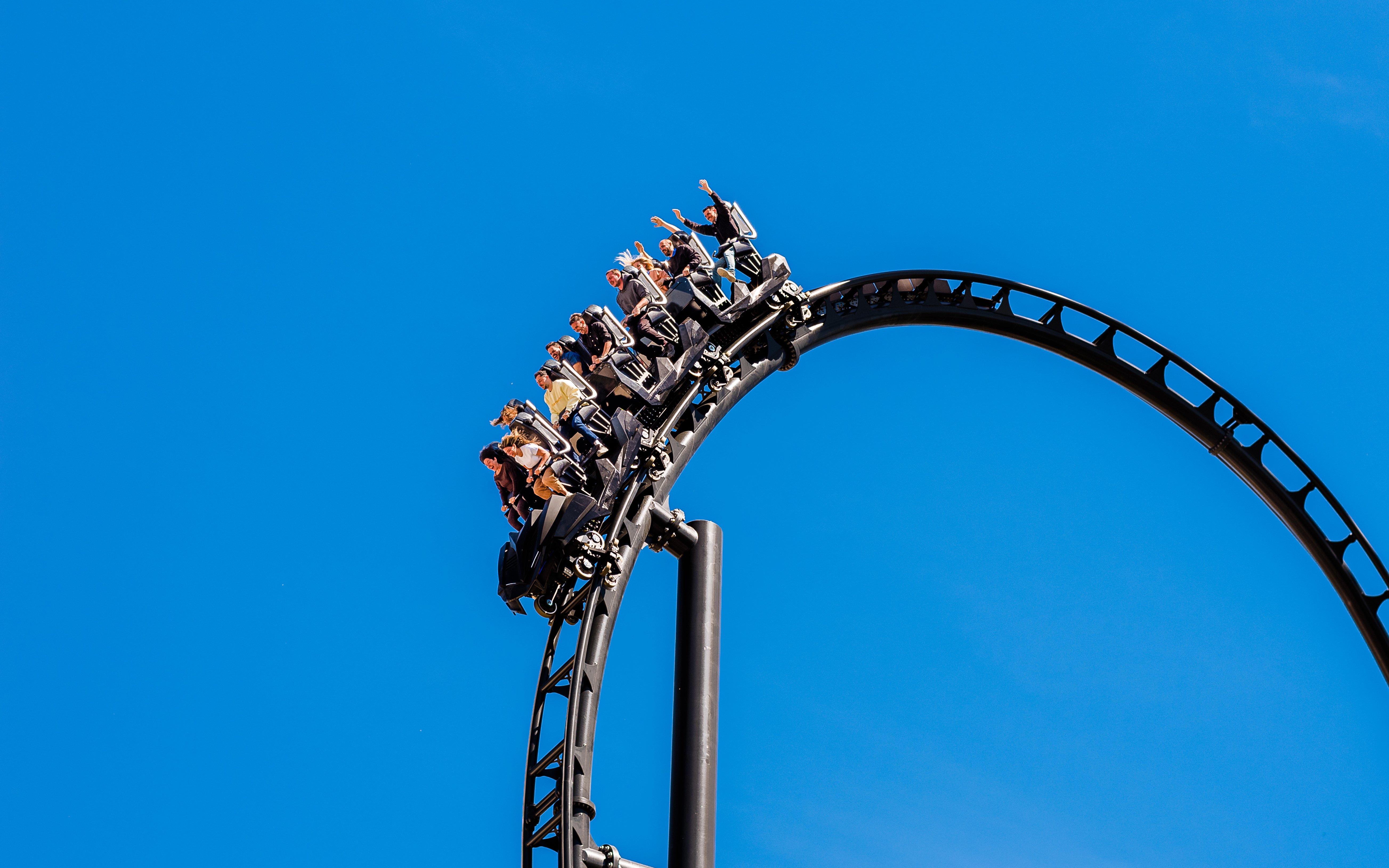 Roller coaster loop with riders at Batman Gotham City Escape, Parque Warner Madrid.