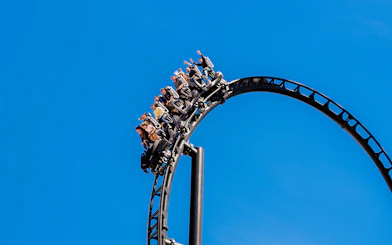 Roller coaster loop with riders at Batman Gotham City Escape, Parque Warner Madrid.