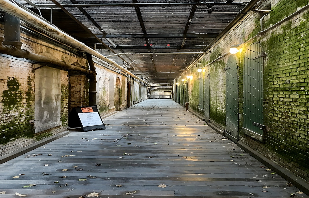 Walkway to prison cells with mossy walls on Alcatraz Island, San Francisco.
