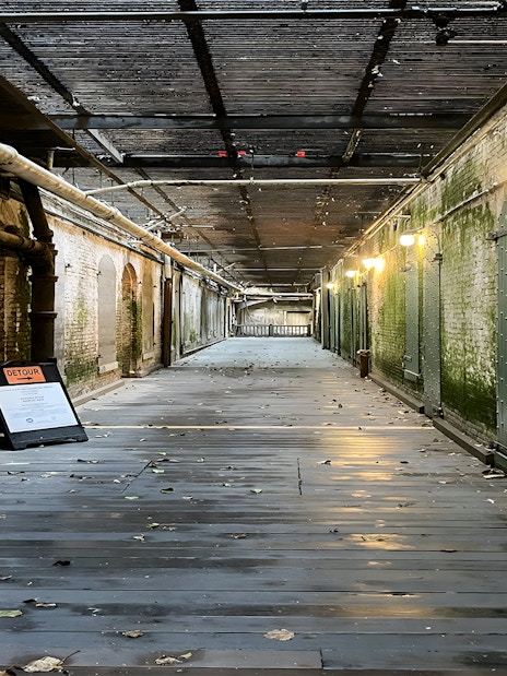 Walkway to prison cells with mossy walls on Alcatraz Island, San Francisco.